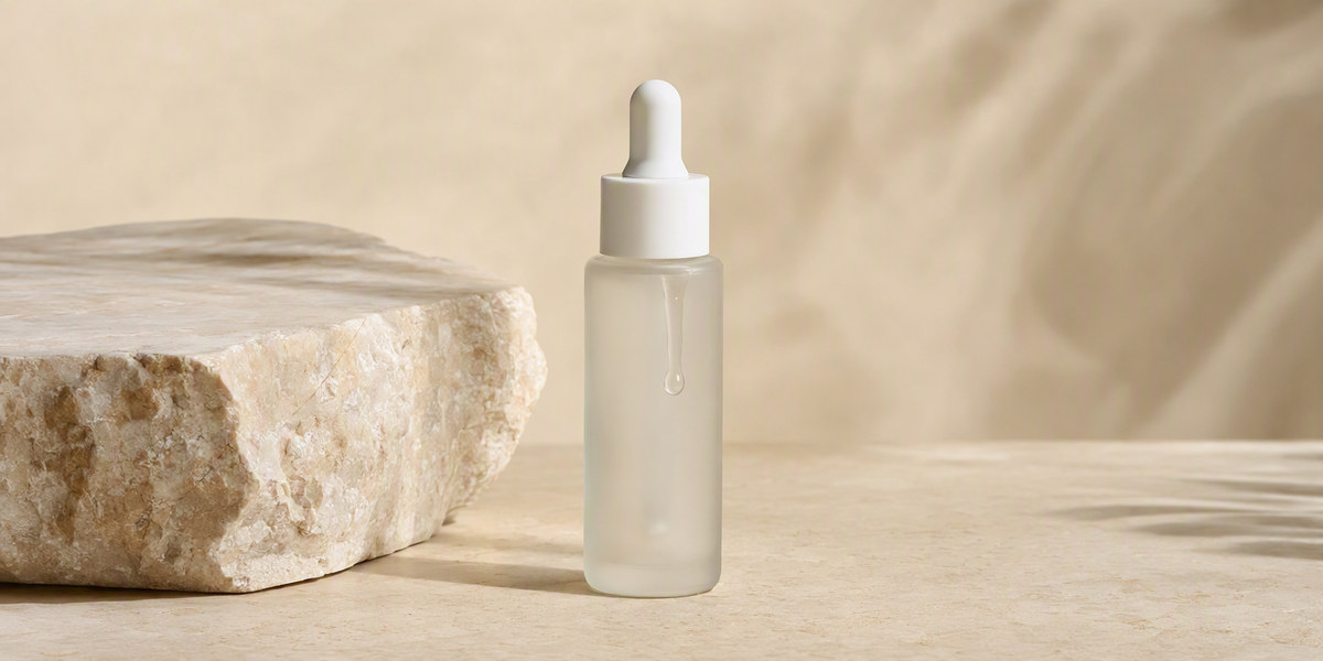 Unbranded frosted glass serum bottle representing prebiotic skincare formulation